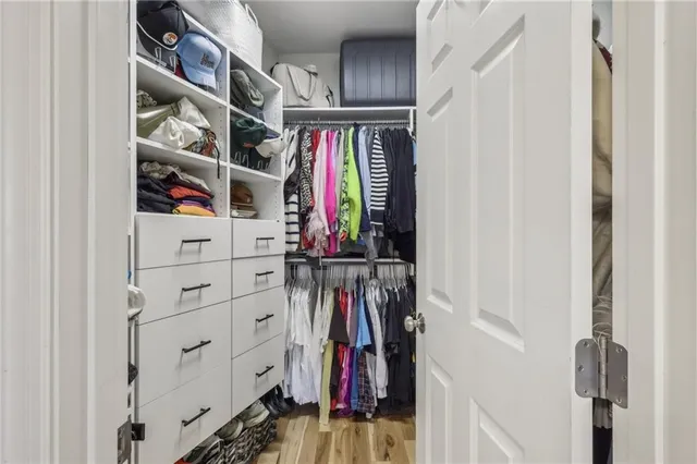 a view of walk in closet with clothes and shoes