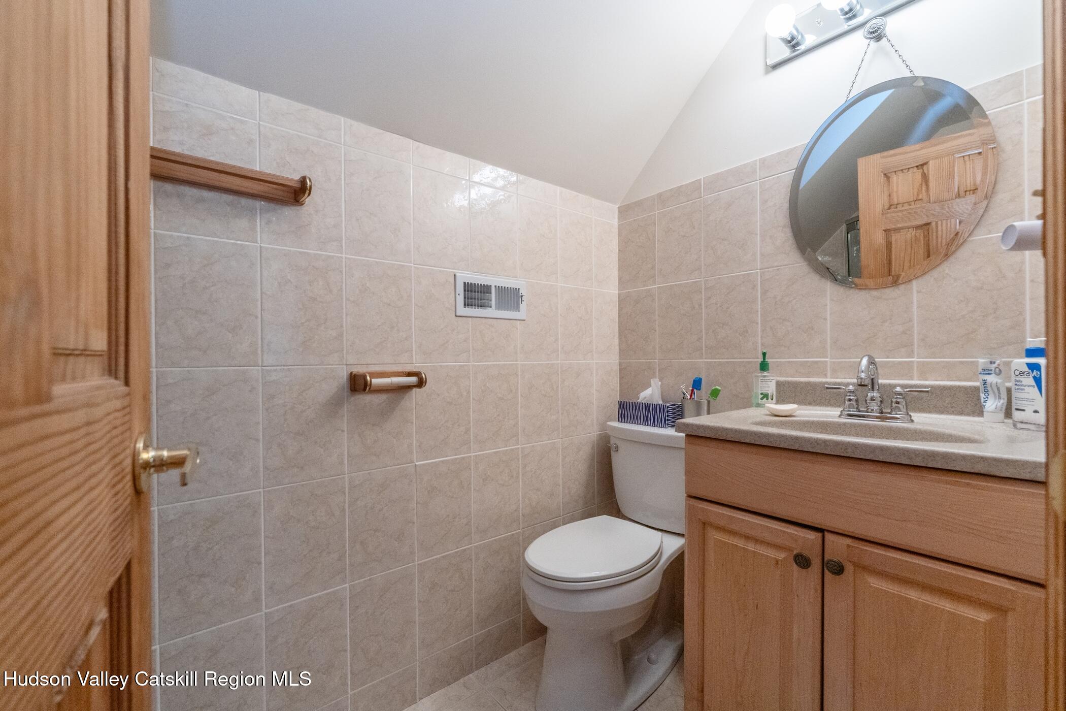 140 Stone Dock Road High Falls, NY 12440 - Photo 26 of 42 a bathroom with a toilet a sink a mirror and vanity