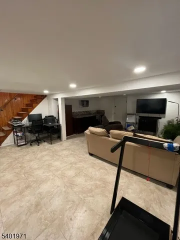 a living room with furniture a flat screen tv and kitchen view