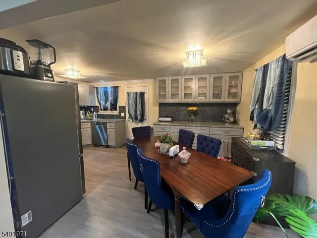 a living room with stainless steel appliances furniture a rug and a kitchen view