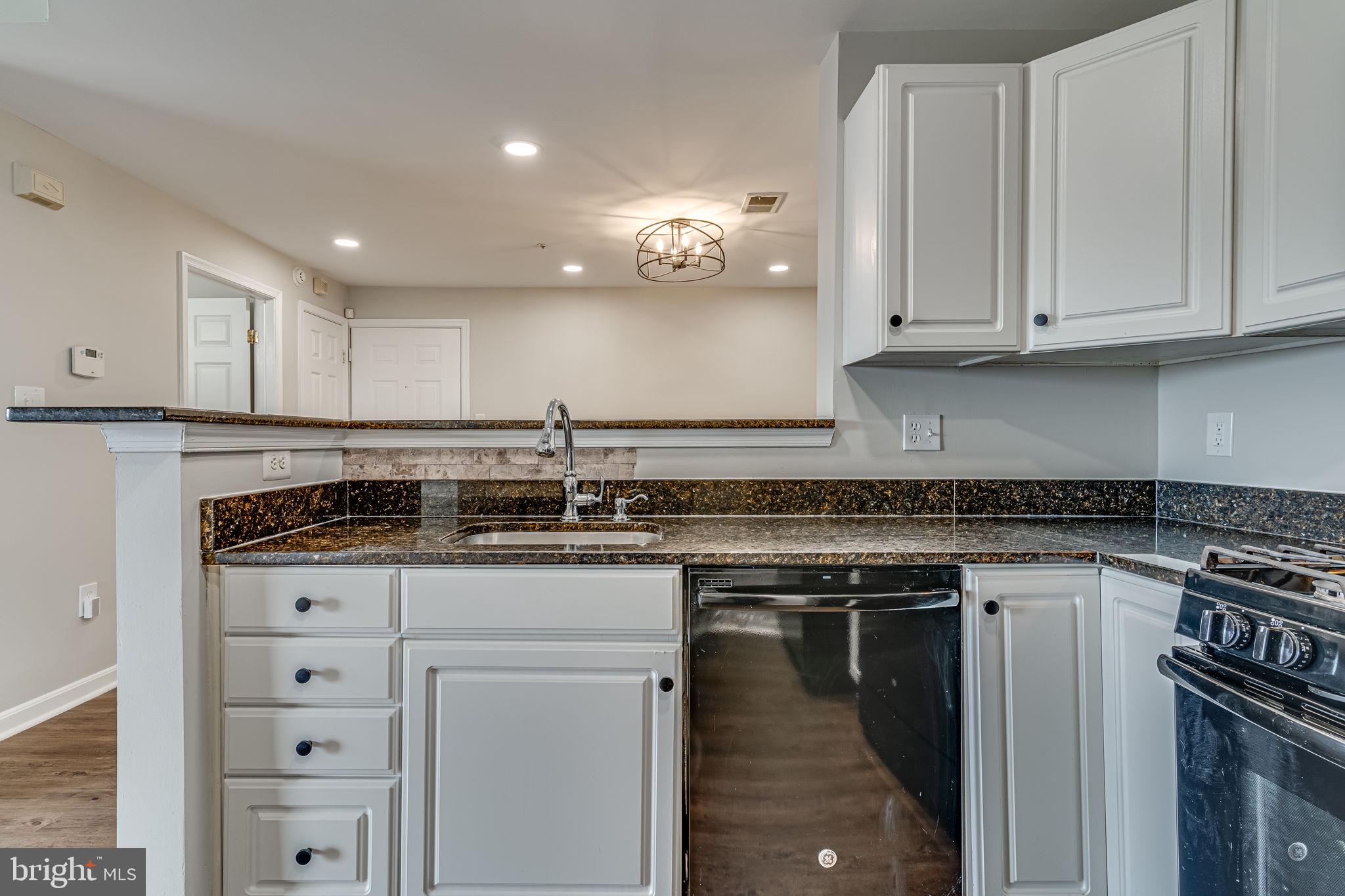 1067 Gardenview Loop, Unit 304 Woodbridge, VA 22191 - Photo 11 of 36 a kitchen with granite countertop a sink stainless steel appliances and cabinets