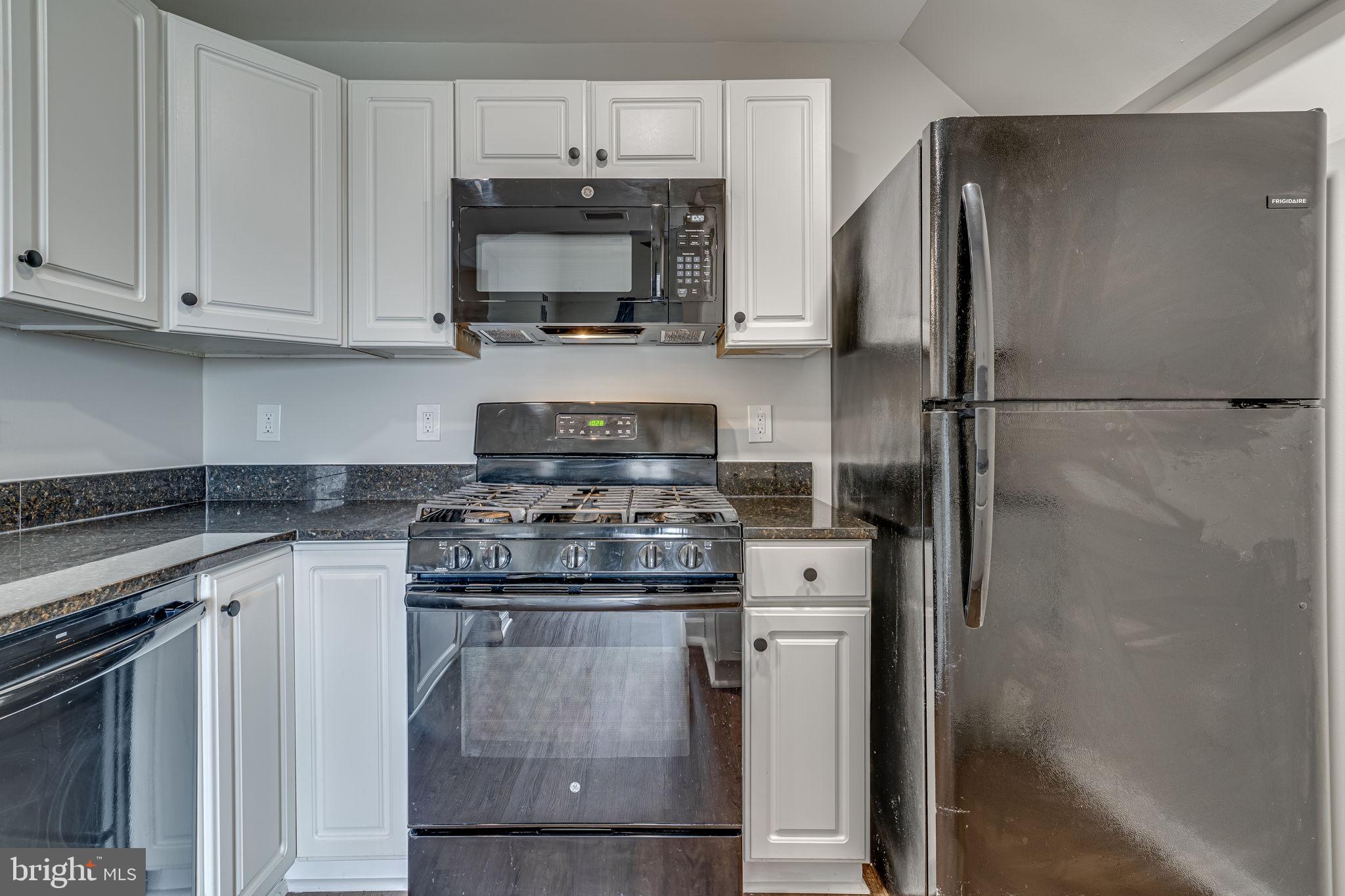 1067 Gardenview Loop, Unit 304 Woodbridge, VA 22191 - Photo 12 of 36 a kitchen with a stove microwave and refrigerator