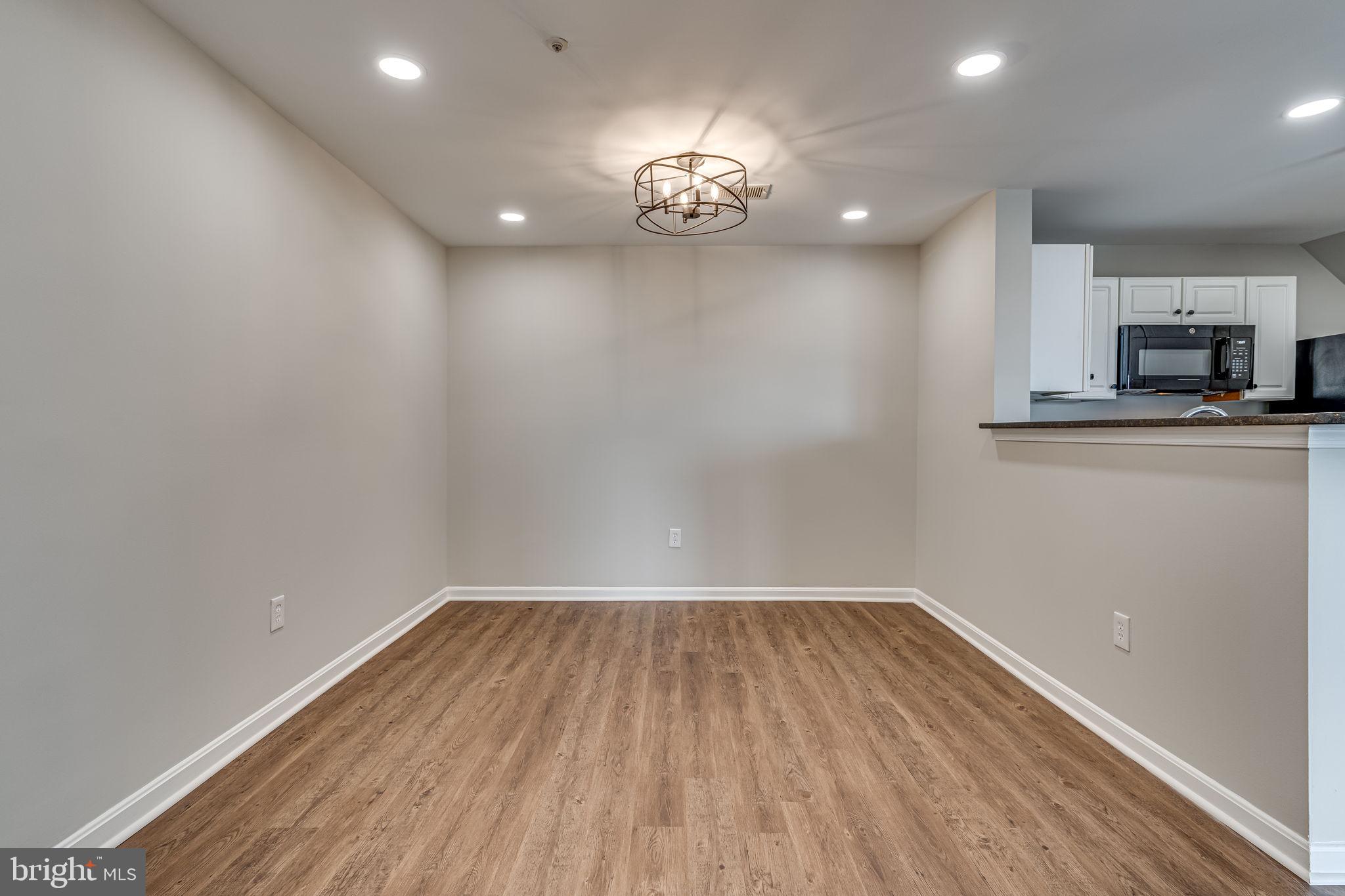 1067 Gardenview Loop, Unit 304 Woodbridge, VA 22191 - Photo 13 of 36 a view of kitchen and empty room with wooden floor