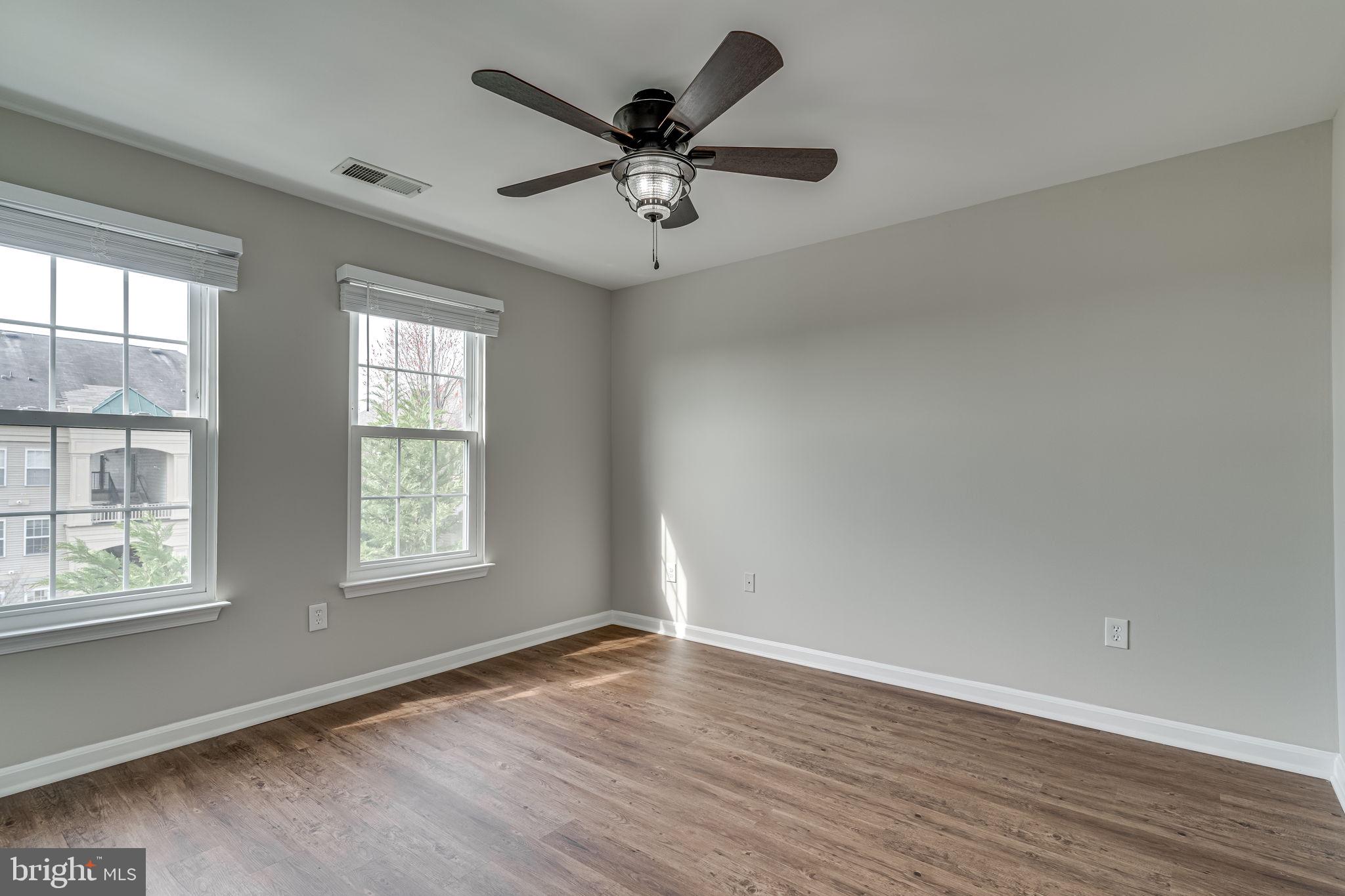 1067 Gardenview Loop, Unit 304 Woodbridge, VA 22191 - Photo 15 of 36 an empty room with wooden floor and windows