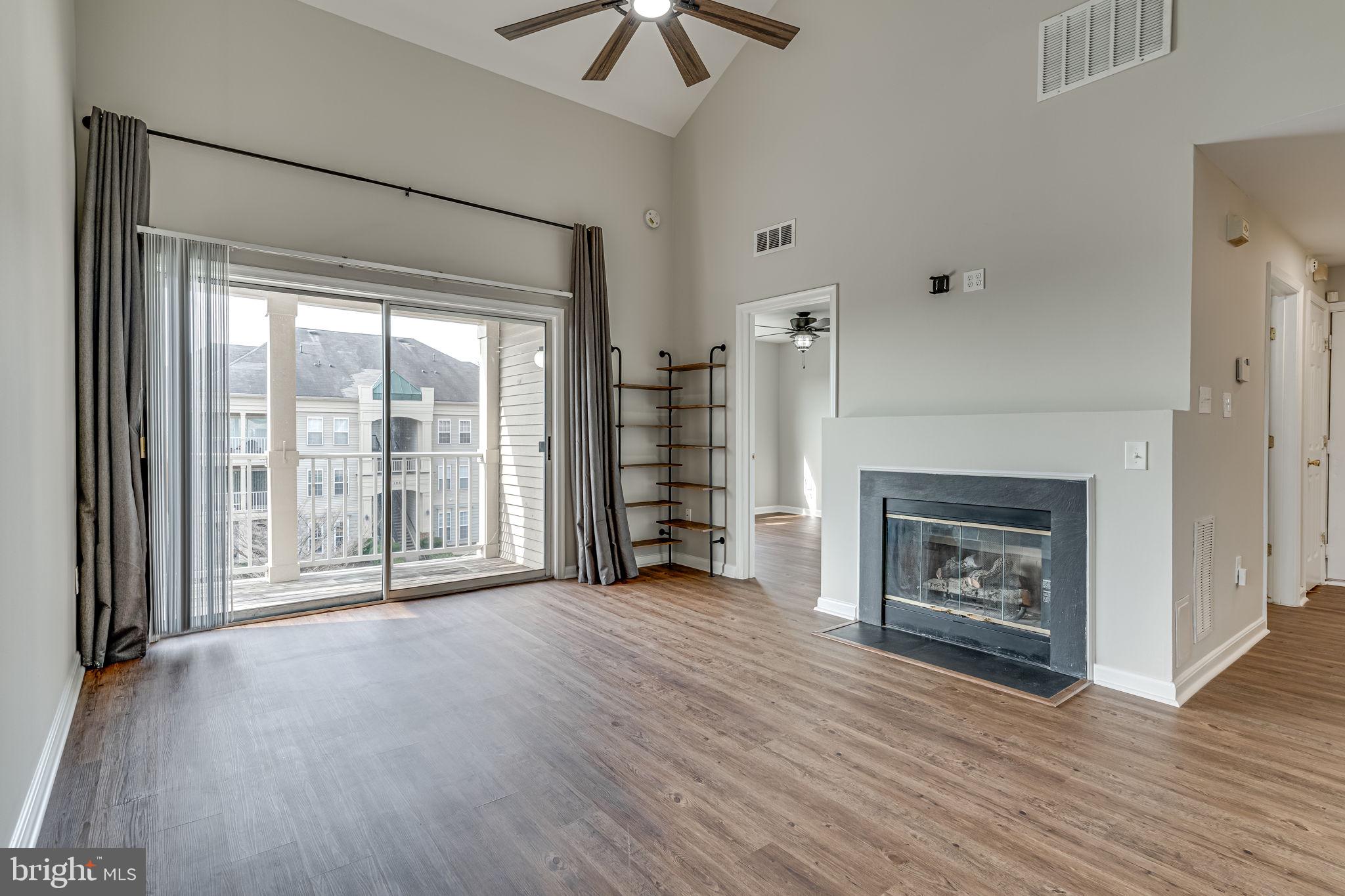 1067 Gardenview Loop, Unit 304 Woodbridge, VA 22191 - Photo 3 of 36 a view of a livingroom with a fireplace wooden floor and window