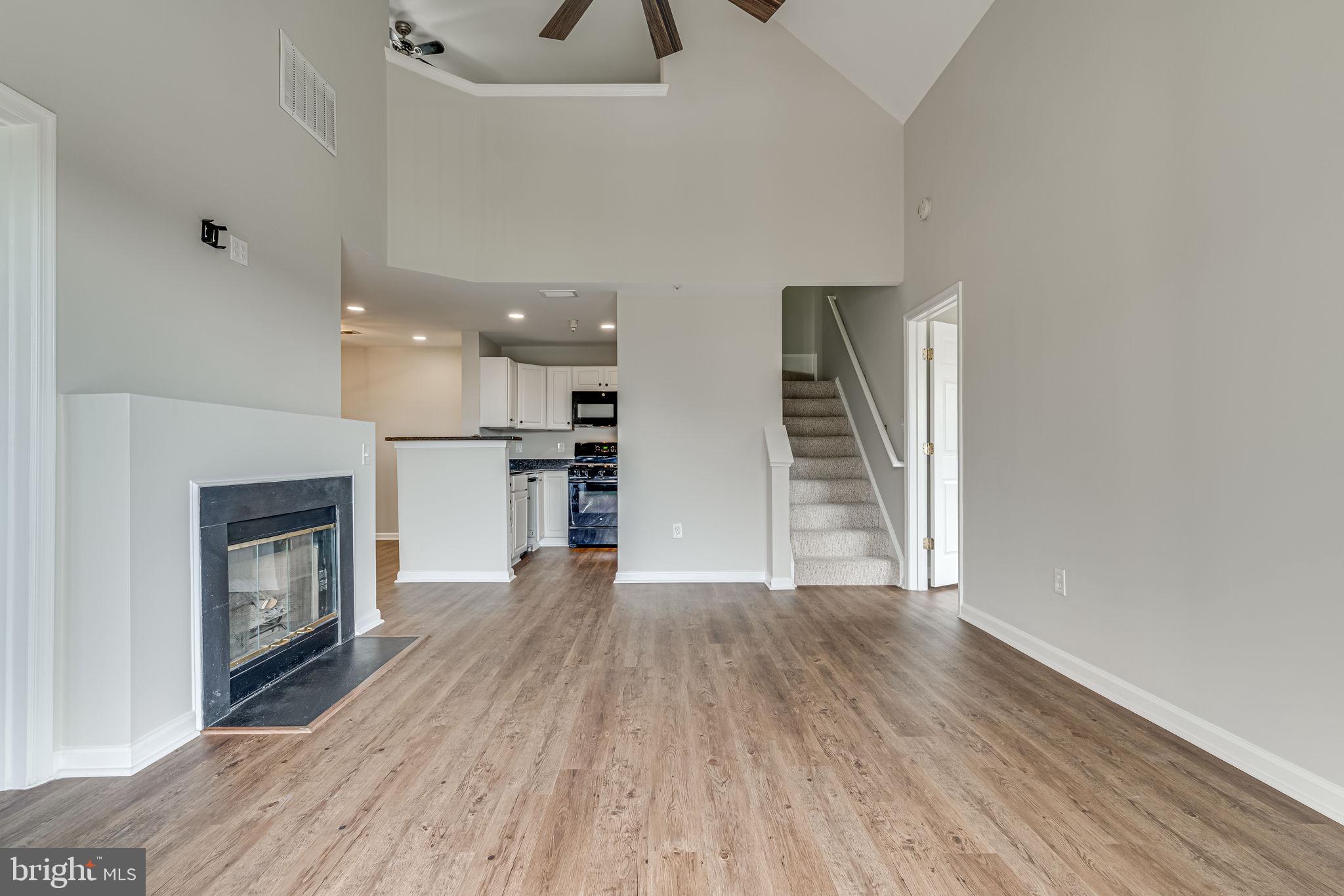1067 Gardenview Loop, Unit 304 Woodbridge, VA 22191 - Photo 8 of 36 an empty room with wooden floor fireplace and windows