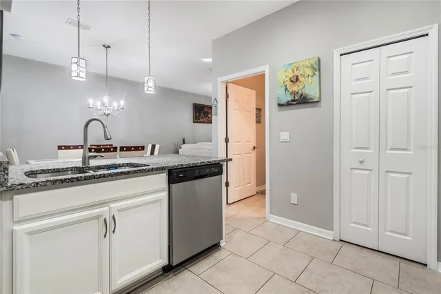 a kitchen with kitchen island granite countertop a sink cabinets and stainless steel appliances