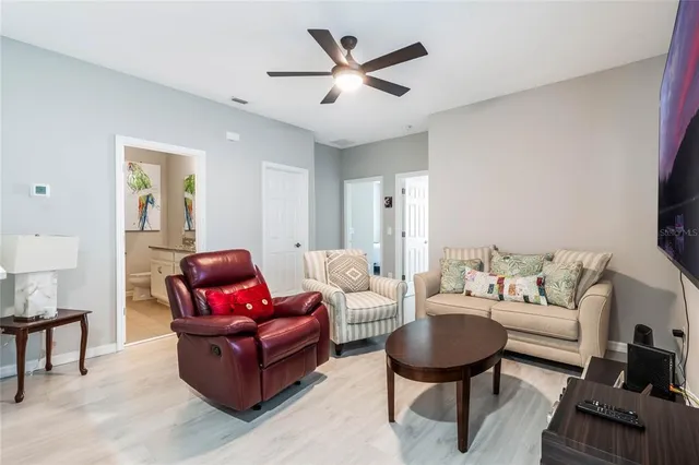 a living room with furniture a rug and a ceiling fan