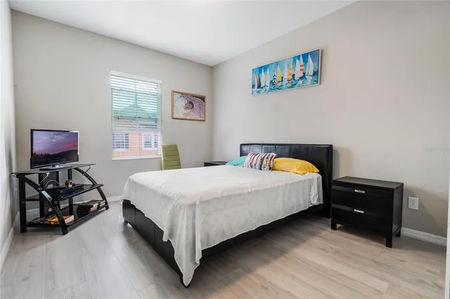 a bedroom with a bed and wooden floor