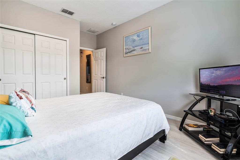 17523 Promenade Drive Clermont, FL 34711 - Photo 24 of 44 a bedroom with a bed and a flat screen tv