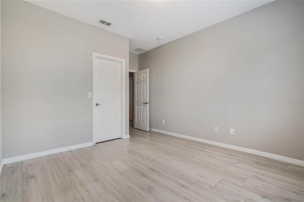 17523 Promenade Drive Clermont, FL 34711 - Photo 26 of 44 a view of an empty room with wooden floor