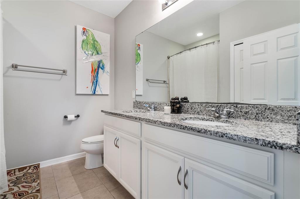17523 Promenade Drive Clermont, FL 34711 - Photo 27 of 44 a bathroom with a granite countertop sink and a mirror