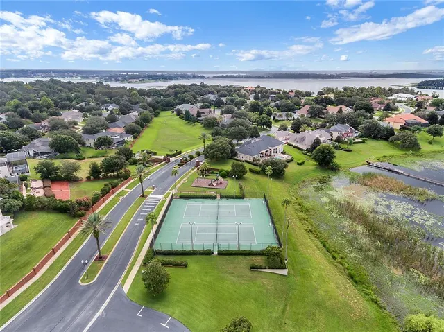 an aerial view of a house with a yard and lake view