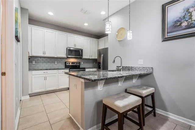 a kitchen with cabinets a sink and a stove top oven with wooden floor