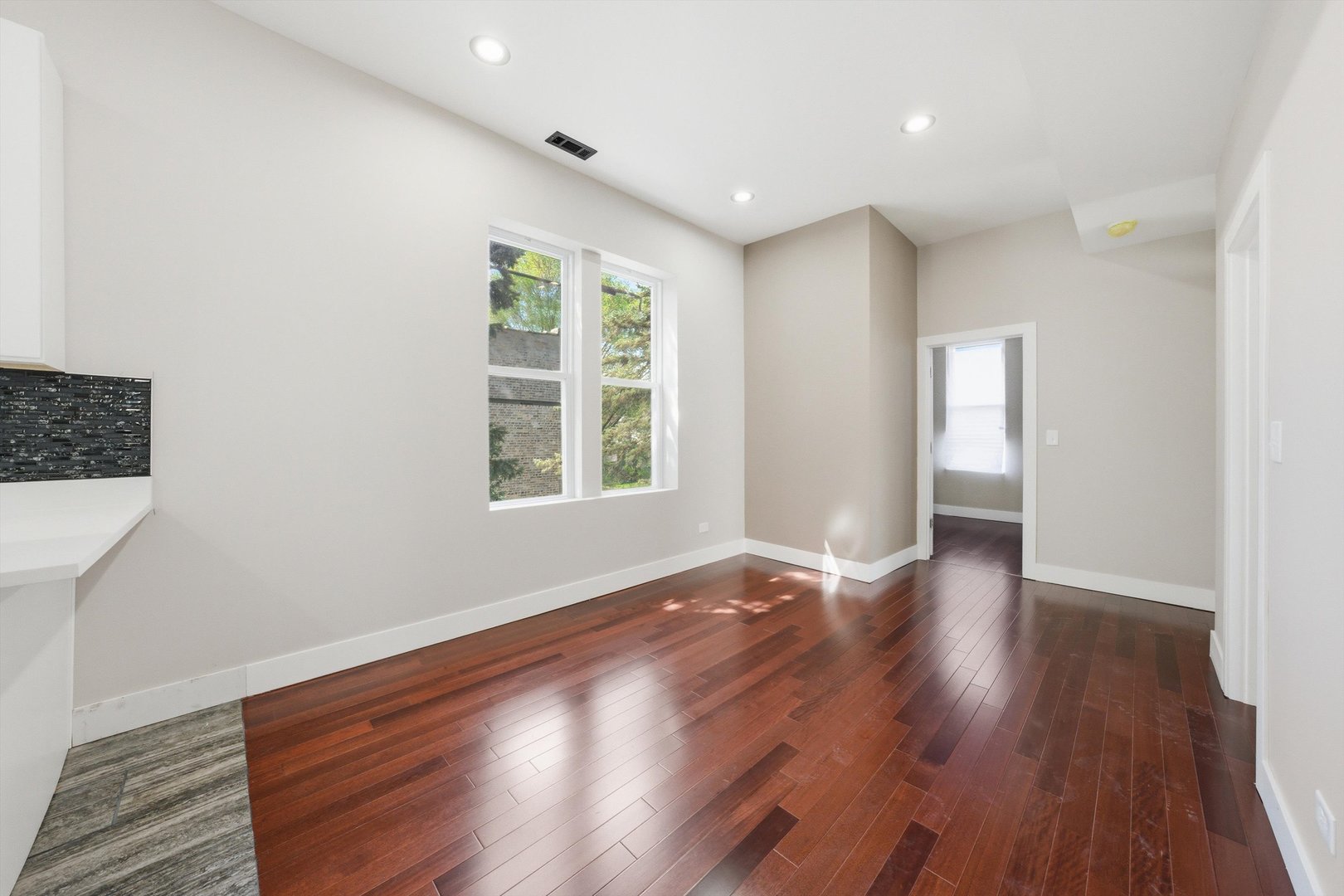 7017 South Normal Boulevard Chicago, IL 60621 - Photo 14 of 23 a view of an empty room with wooden floor and windows