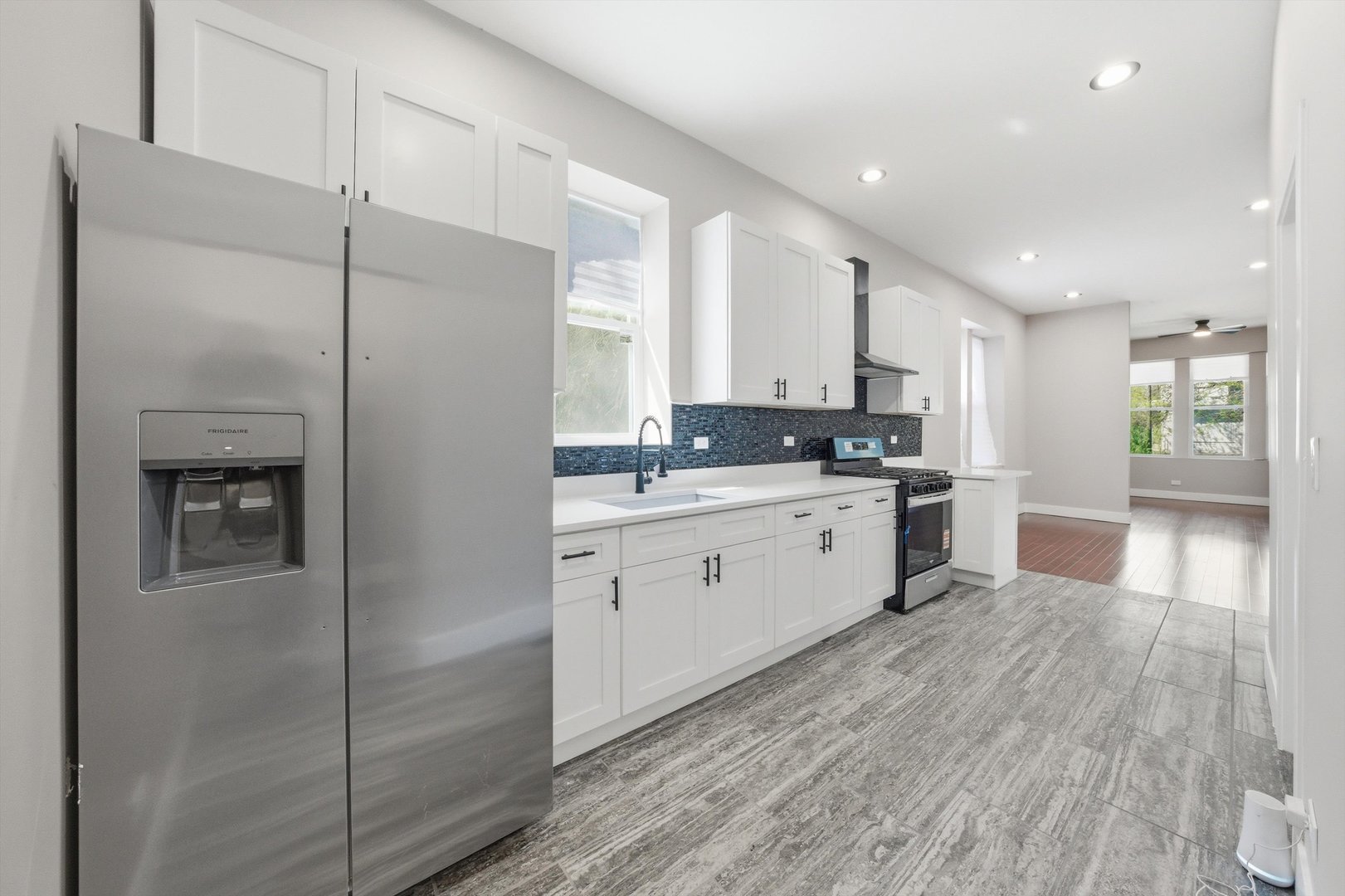 7017 South Normal Boulevard Chicago, IL 60621 - Photo 7 of 23 a kitchen with stainless steel appliances kitchen island granite countertop a refrigerator a sink a stove and white cabinets with wooden floor