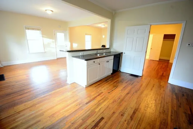 a kitchen with granite countertop wooden floors and wide window