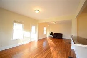 a view of a room with wooden floor and furniture