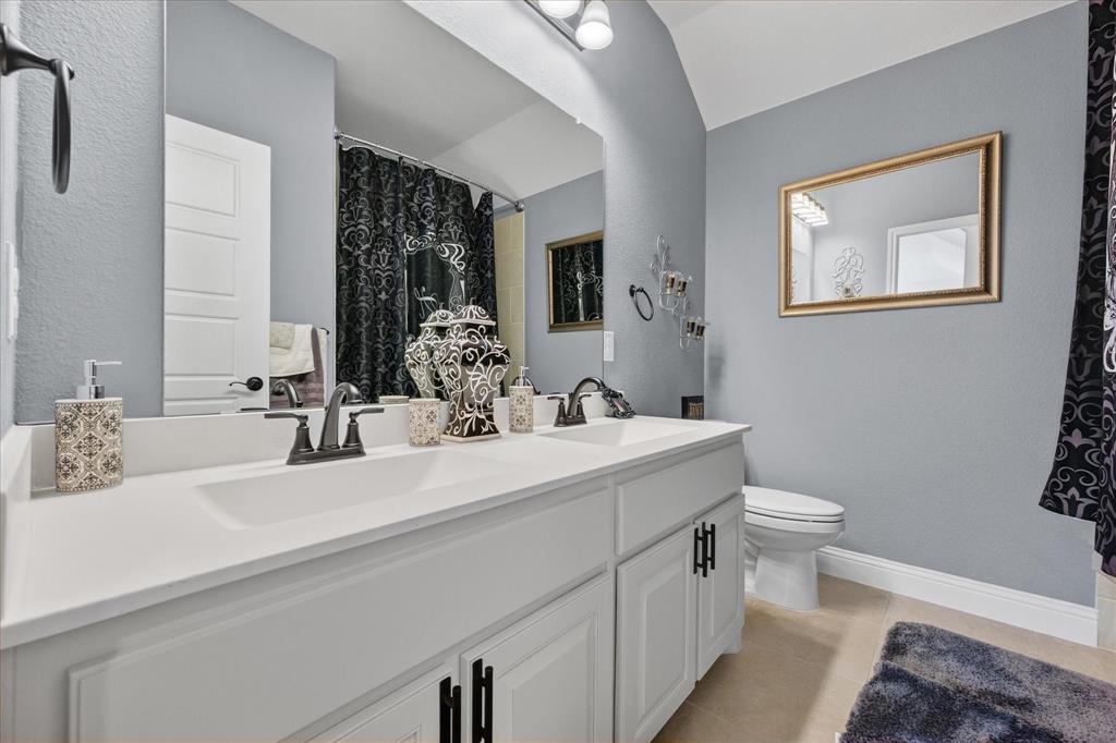 4434 Verbena Street Midlothian, TX 76065 - Photo 26 of 32 a bathroom with a toilet sink and mirror