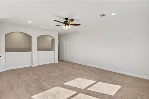 a view of a big room with a ceiling fan and window