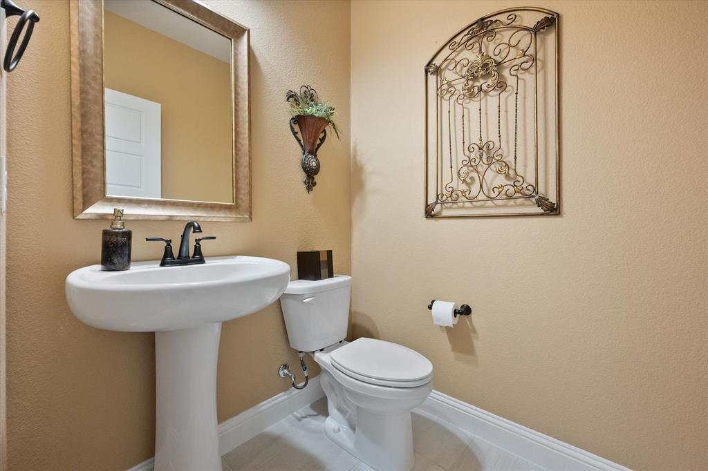 4434 Verbena Street Midlothian, TX 76065 - Photo 5 of 32 a bathroom with a toilet sink and mirror