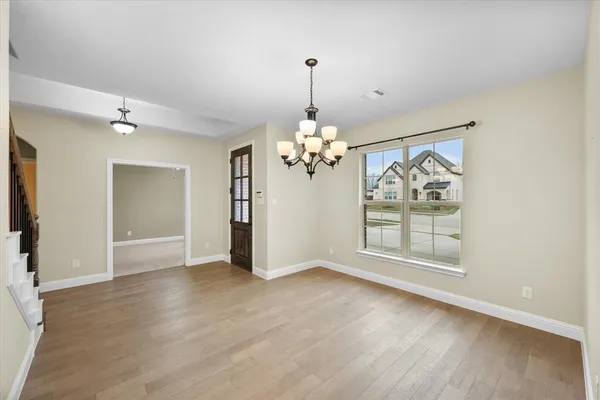 a view of a chandelier in big room and wooden floor