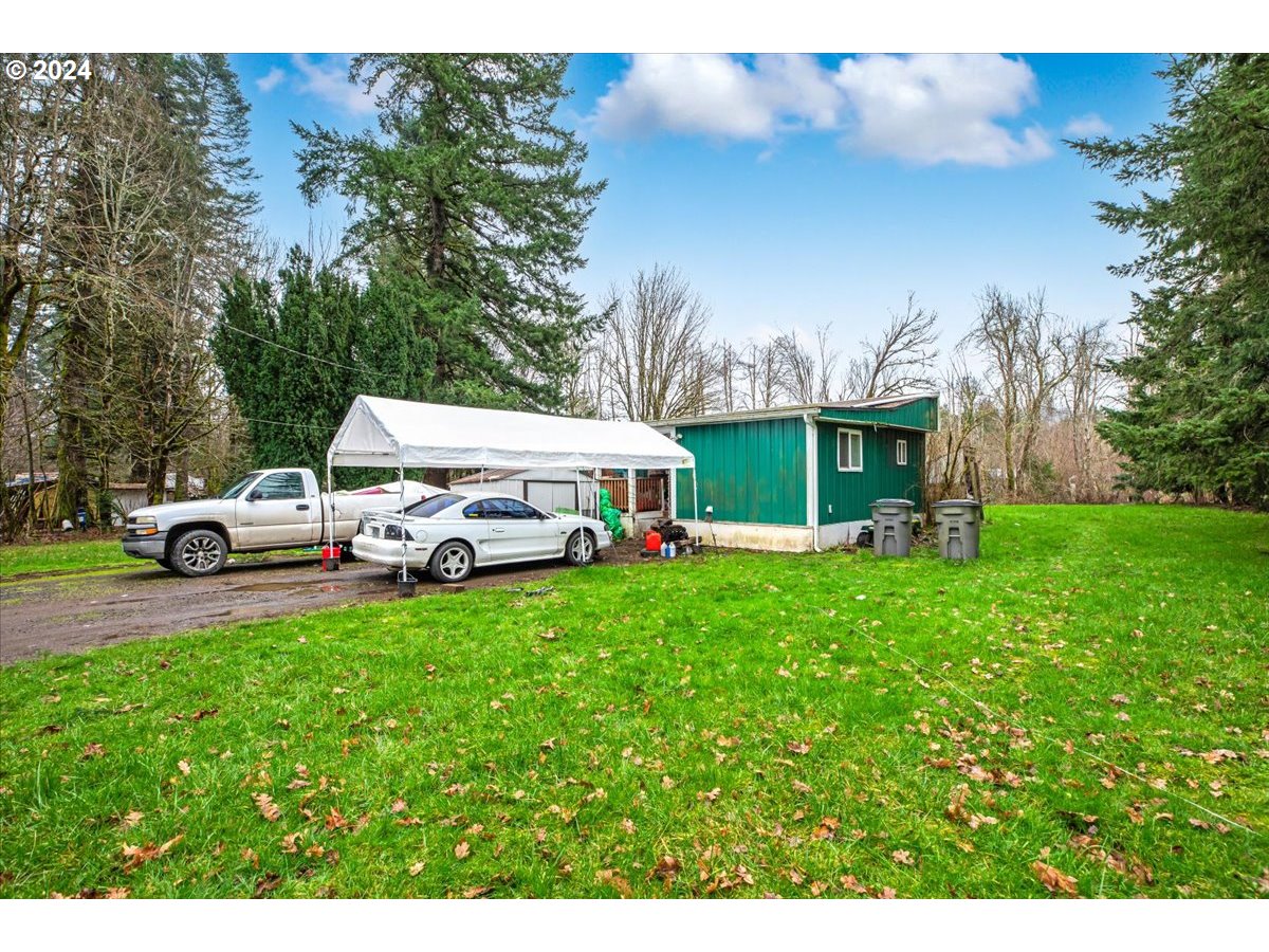 29700 Joe Day Way Grand Ronde, OR 97347 - Photo 5 of 18 a front view of a house with a garden and car parked