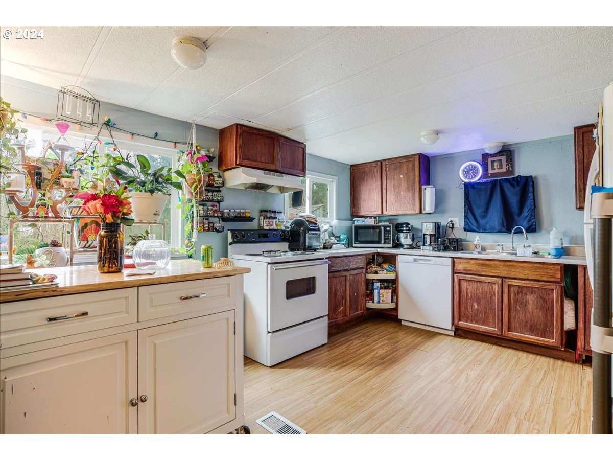 29700 Joe Day Way Grand Ronde, OR 97347 - Photo 7 of 18 a kitchen with stainless steel appliances granite countertop a stove a sink dishwasher and a microwave oven with large wooden cabinets