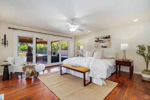 a spacious bedroom with a bed and wooden floor