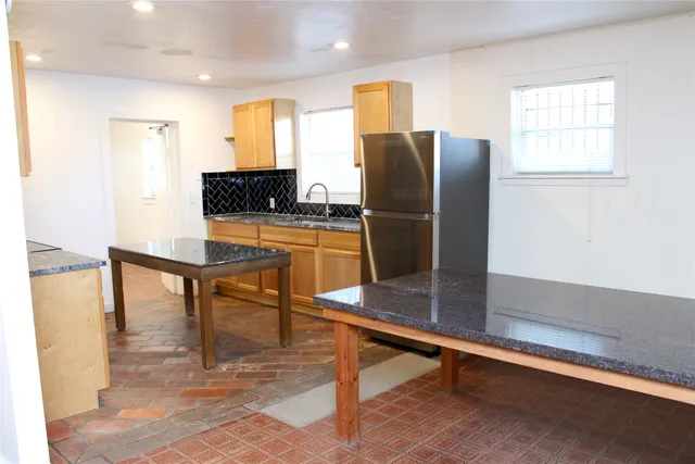 a room with furniture pool table and stainless steel appliances