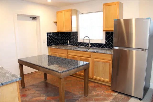 a kitchen with stainless steel appliances granite countertop a refrigerator and a sink