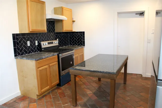 a kitchen with stainless steel appliances granite countertop a stove a sink and a refrigerator