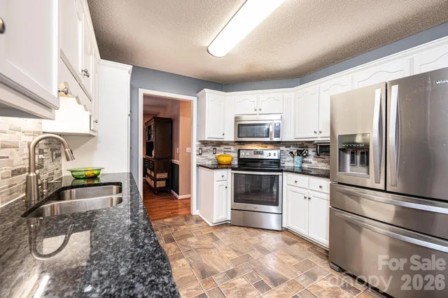 a kitchen with stainless steel appliances granite countertop a sink a stove and a granite counter tops