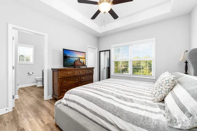 a bedroom with a bed and a flat tv screen on dresser