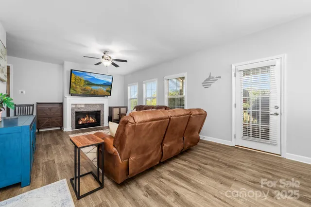 a living room with furniture a fireplace and a flat screen tv