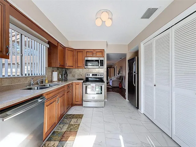 a kitchen with stainless steel appliances granite countertop a refrigerator and a stove