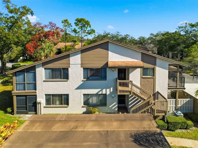 a view of a house with a small yard and wooden fence
