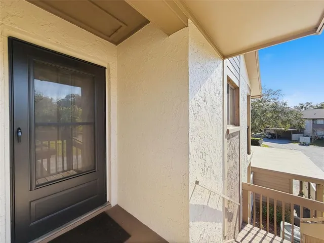 a view of a hallway with bathroom and front door