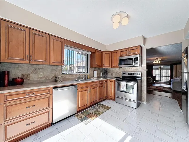 a kitchen with stainless steel appliances granite countertop a stove a sink and a microwave