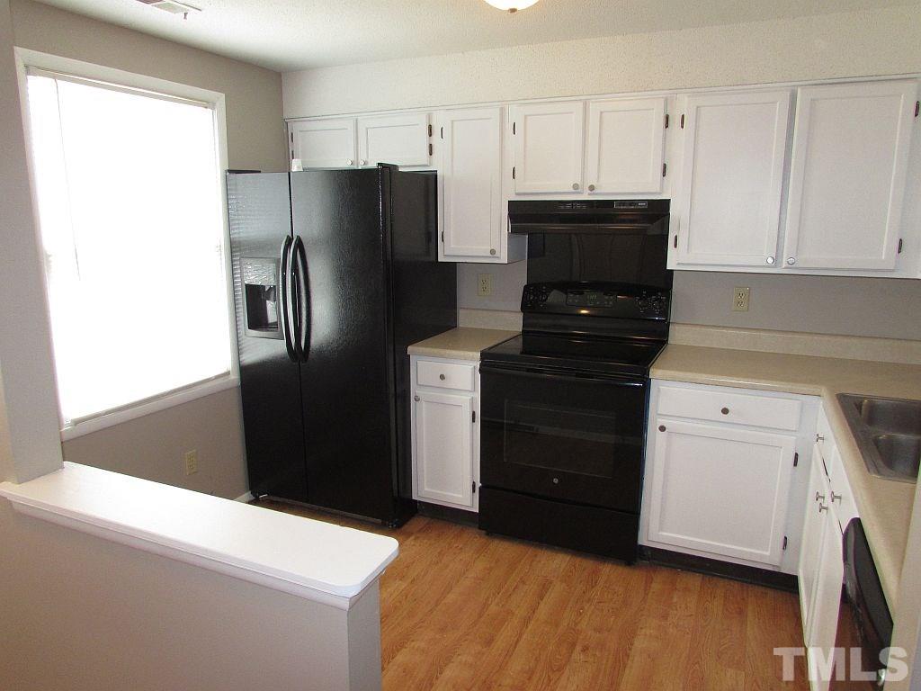 7711 Kelley Court Raleigh, NC 27615 - Photo 2 of 11 a kitchen with a refrigerator and a stove
