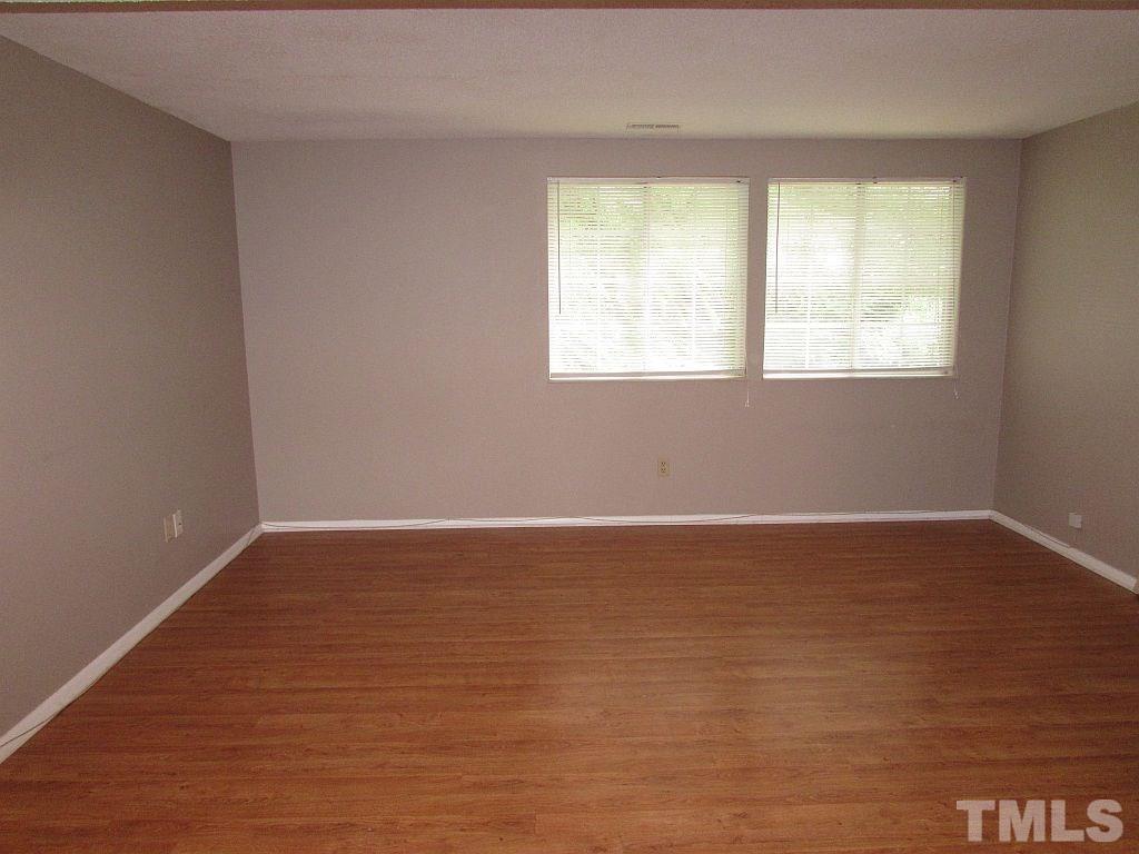 7711 Kelley Court Raleigh, NC 27615 - Photo 3 of 11 a view of an empty room with wooden floor and a window