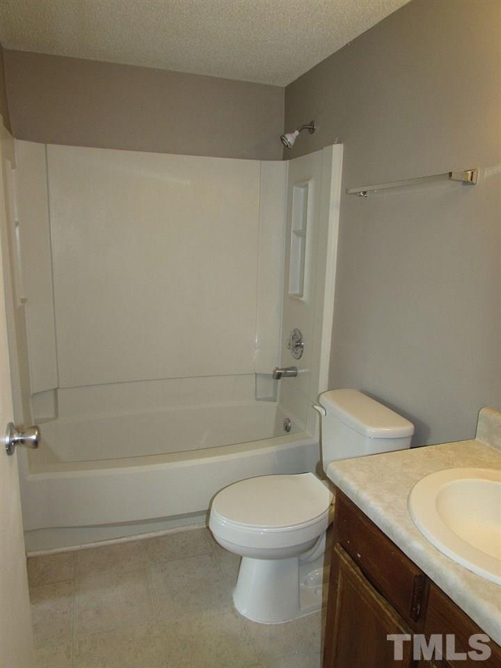 7711 Kelley Court Raleigh, NC 27615 - Photo 10 of 11 a bathroom with a toilet a sink and shower