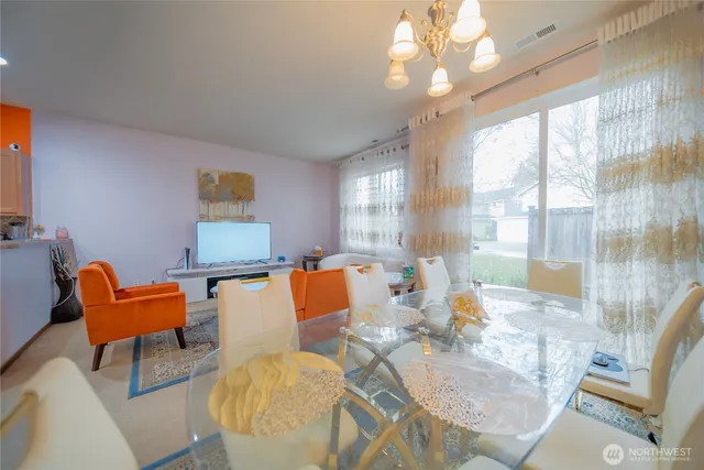 a living room with furniture a large window and a chandelier