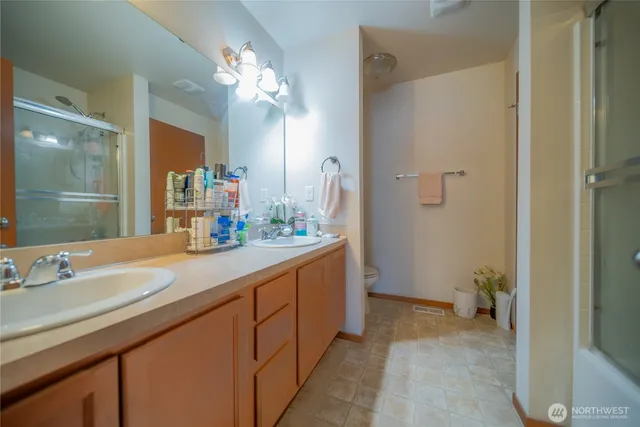 a spacious bathroom with a granite countertop sink a mirror and a shower