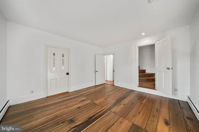 a view of empty room with wooden floor and fireplace