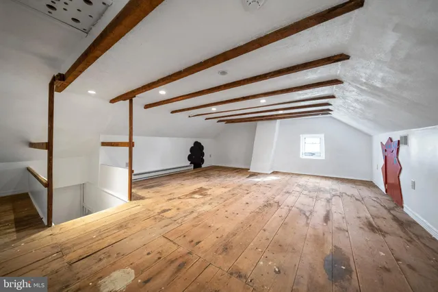 a view of a livingroom with a flesh screen tv and stairs