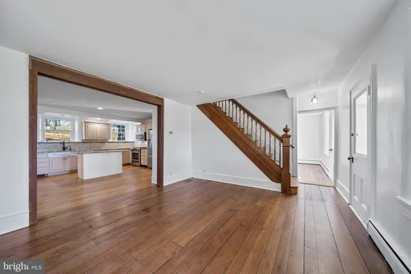 a view of a hallway with wooden floor kitchen view and a faucet
