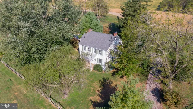 a view of house with yard and trees in the background