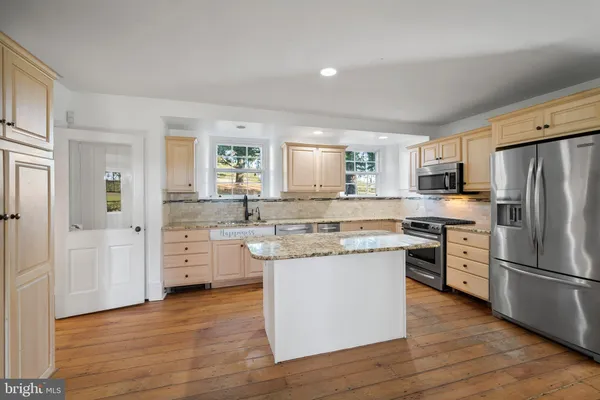 a kitchen with stainless steel appliances a refrigerator sink and cabinets