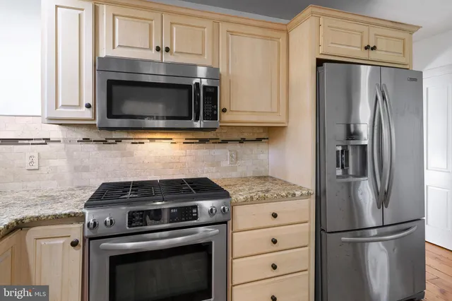a kitchen with cabinets stainless steel appliances and a counter space